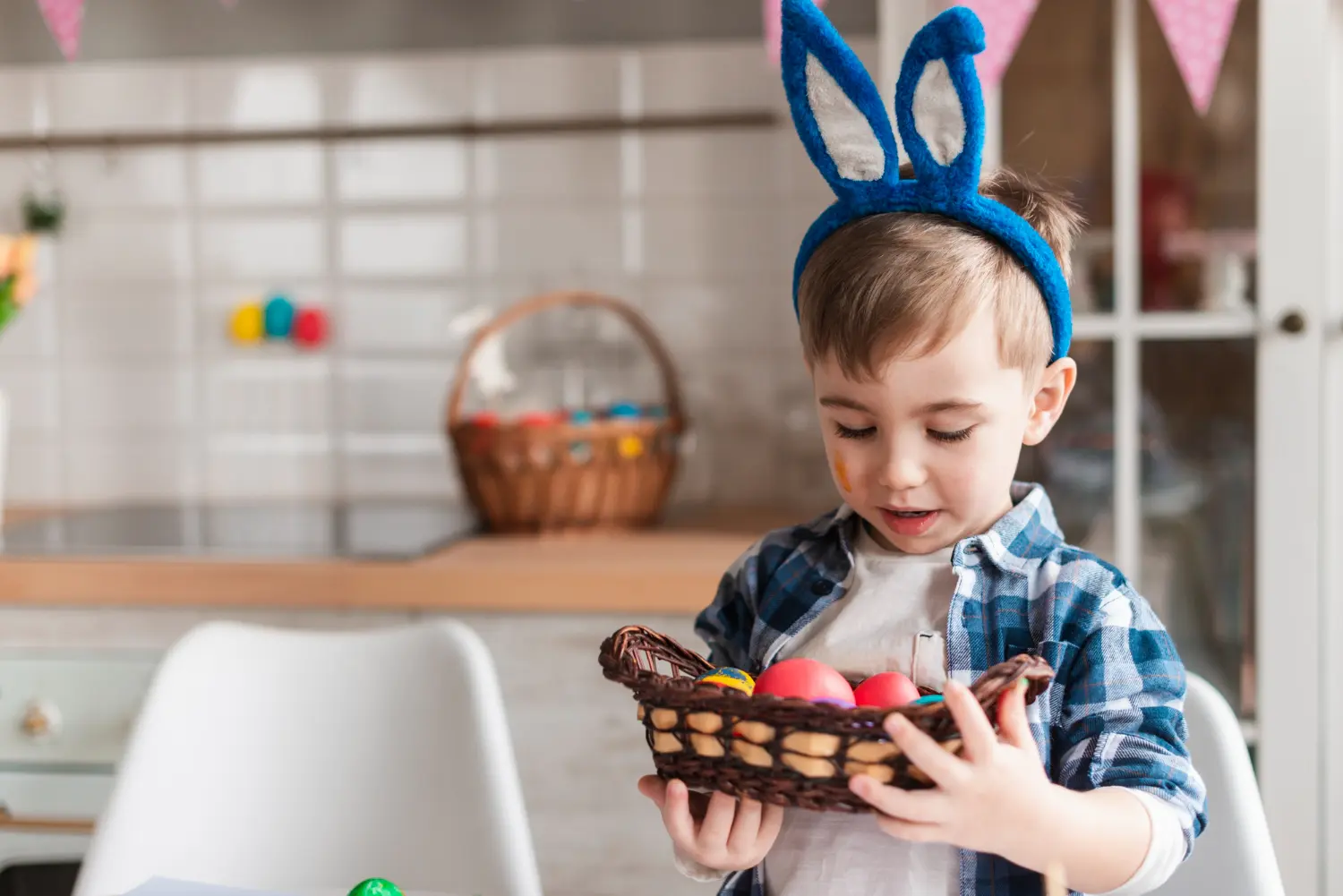 Mains d'une nounou tenant les mains d'un enfant à côté de chocolats de Pâques